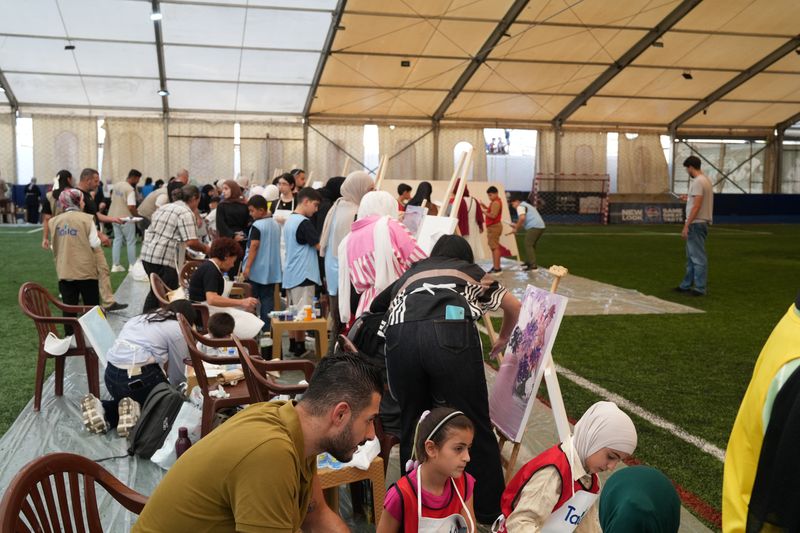 كبار وصغار يرسمون معًا في نشاط فنيّ لتاليا.